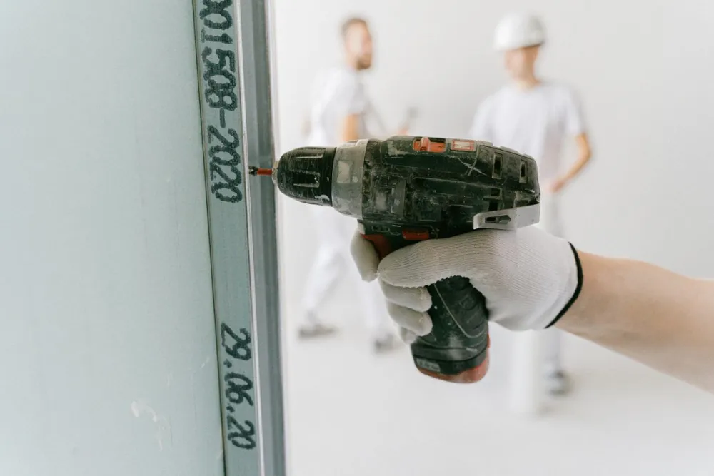 Driving a screw into a drywall panel during installation